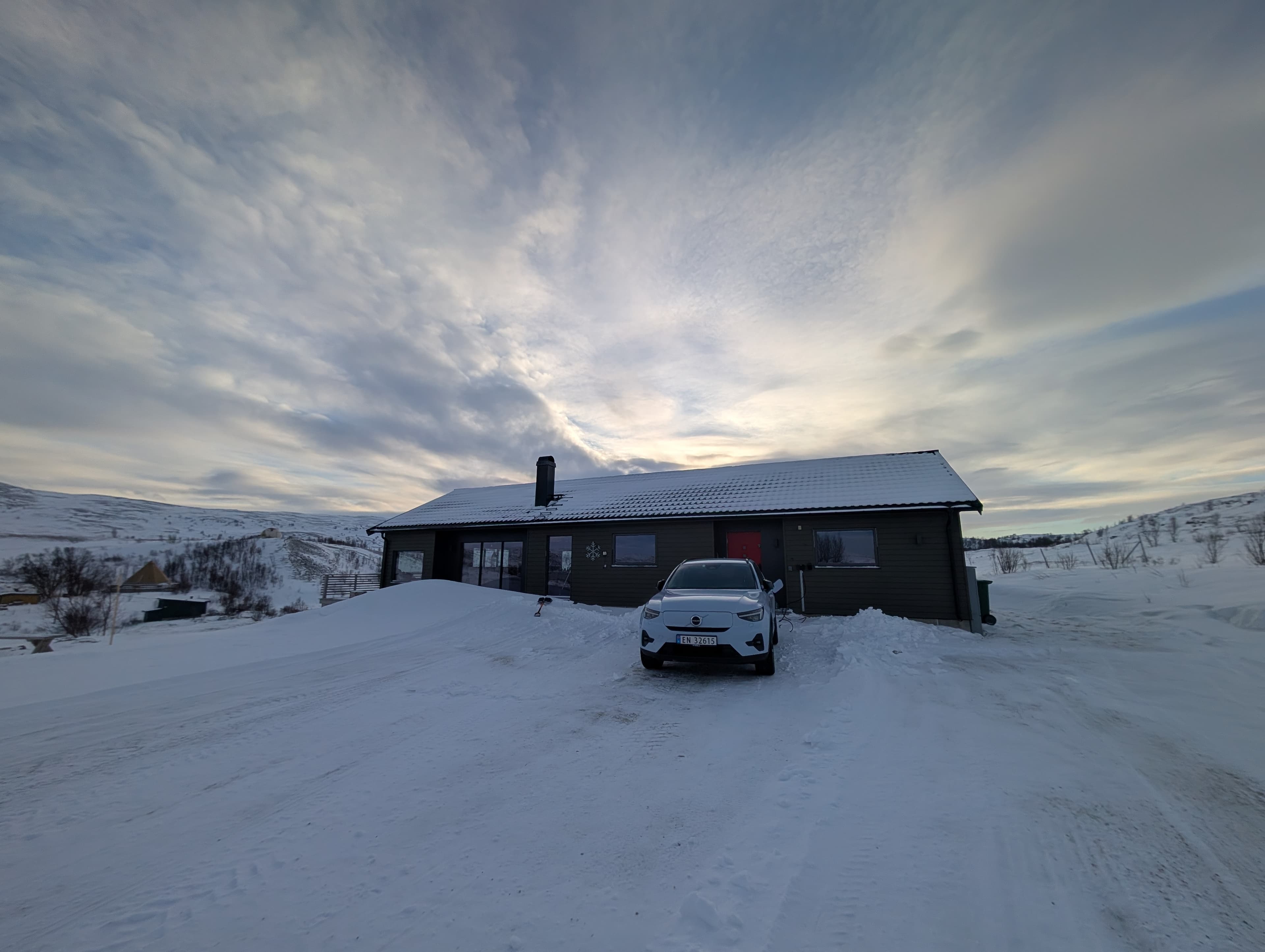 Das dunkle Ferienhaus in der verschneiten arktischen Landschaft – unser Zuhause für zwei Wochen.