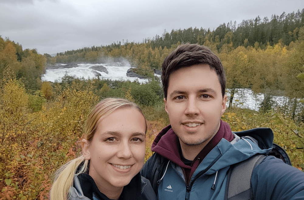 Schneller Fluss in herbstlicher Landschaft mit Bergen im Hintergrund