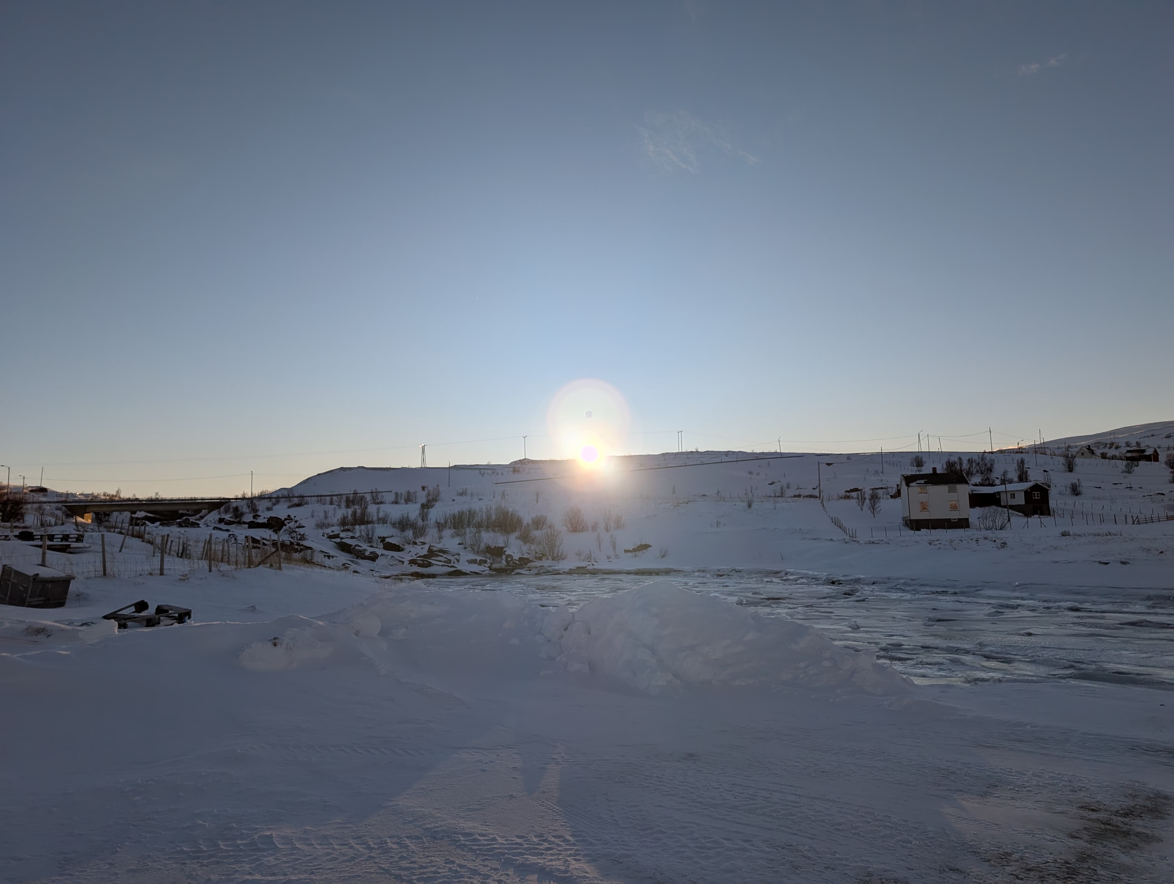 Kokelhafen im Winterlicht mit Eis auf den Booten und einer Person, die am Ufer steht.